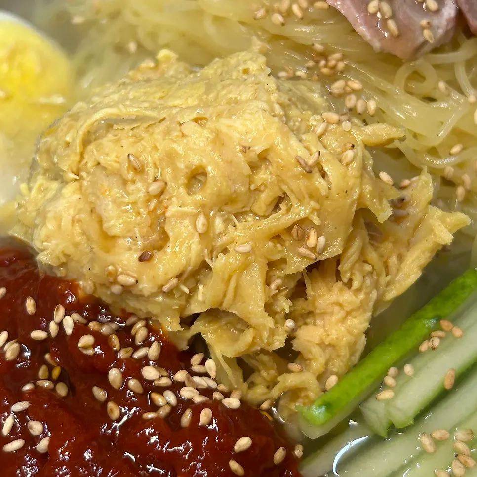Chogye bibim naengmyeon topped with mustard-dressed chicken