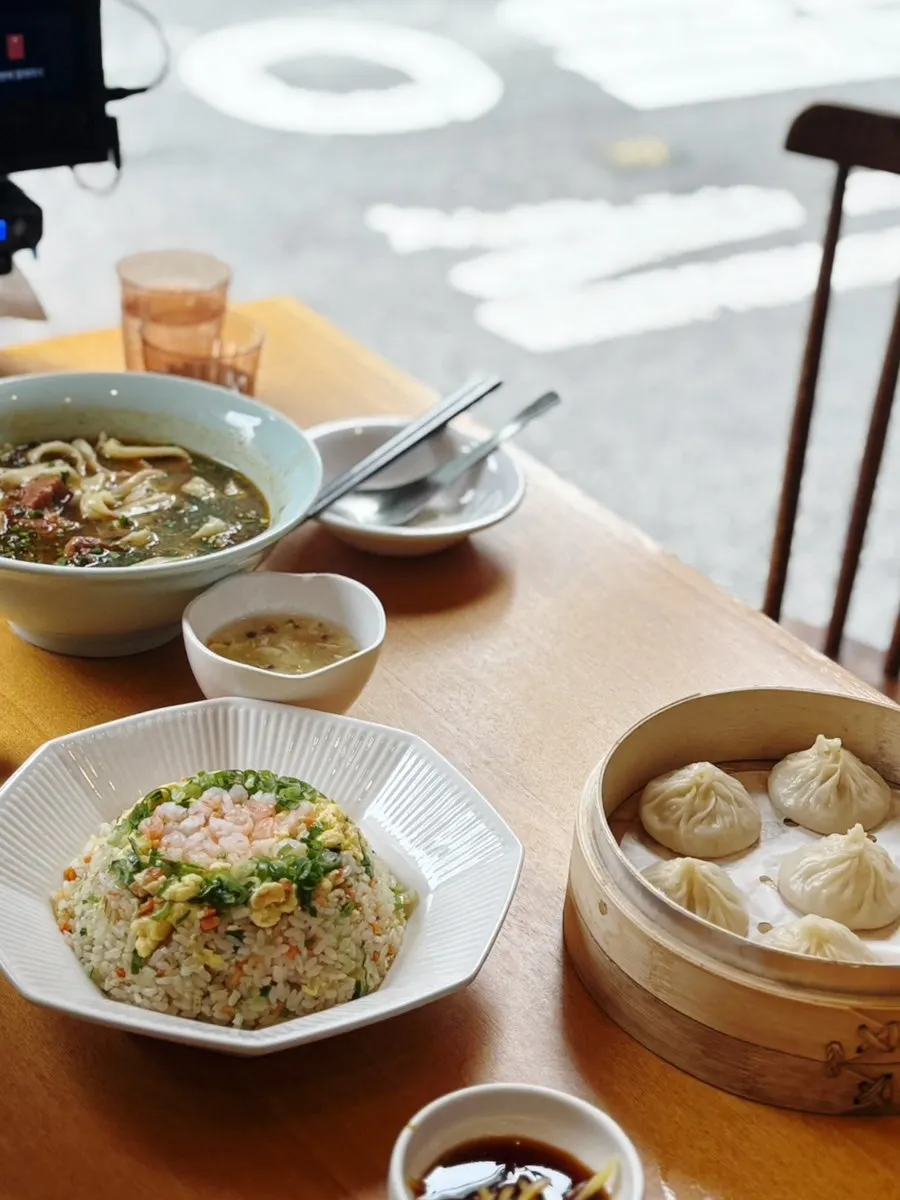 A full table enjoying broth, rice, and dumplings together