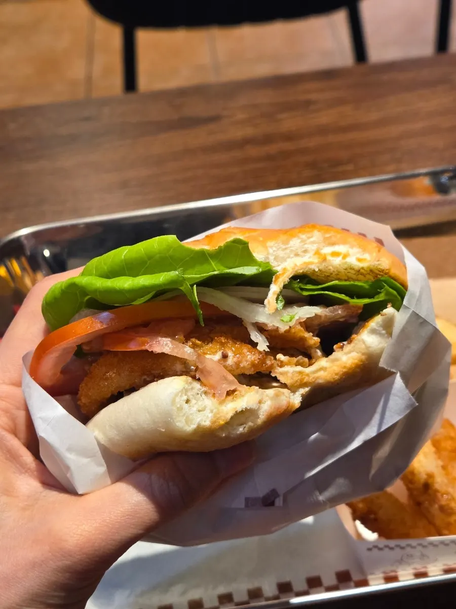 Cross-section of a shrimp burger with whole shrimp and onion rings