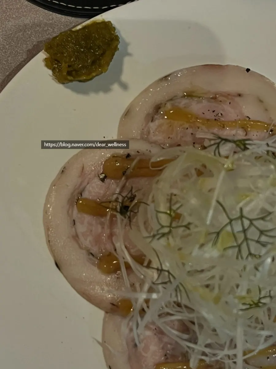 Black pork carpaccio topped with pork jowl and scallions
