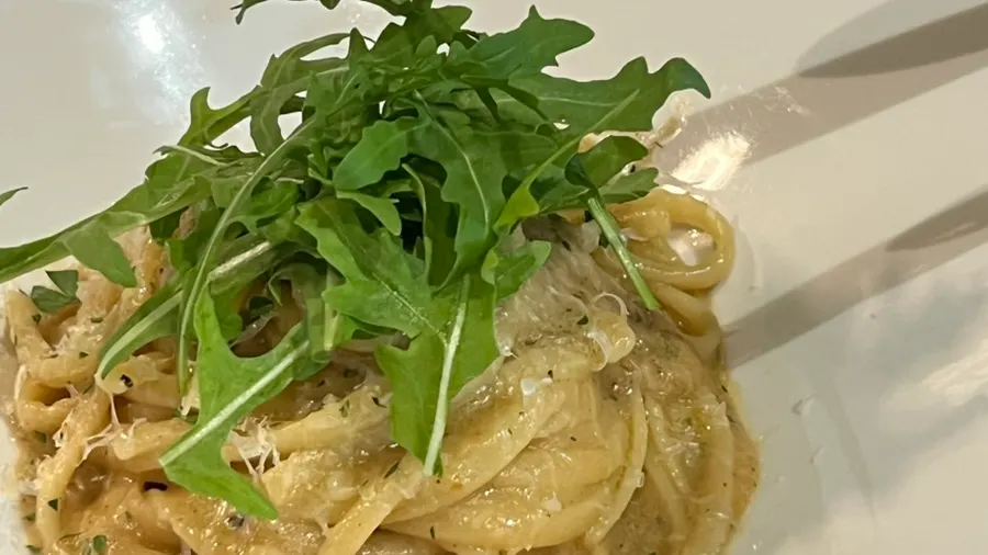 A drink glass next to the linguine