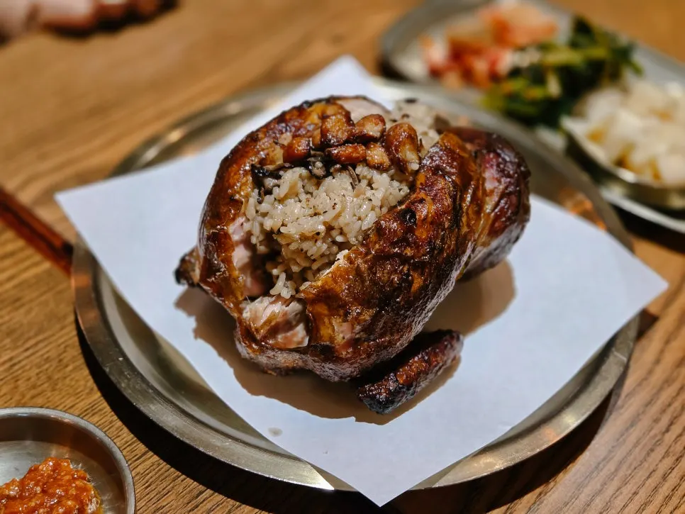 A whole oak-fired neungi mushroom chicken served on the table