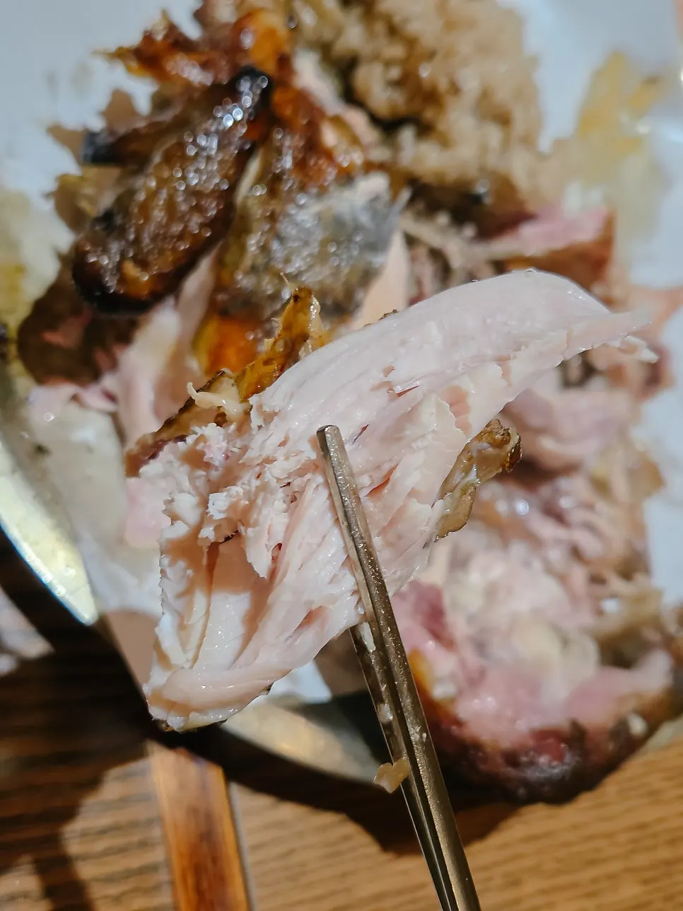 A thick piece of chicken breast picked up with chopsticks
