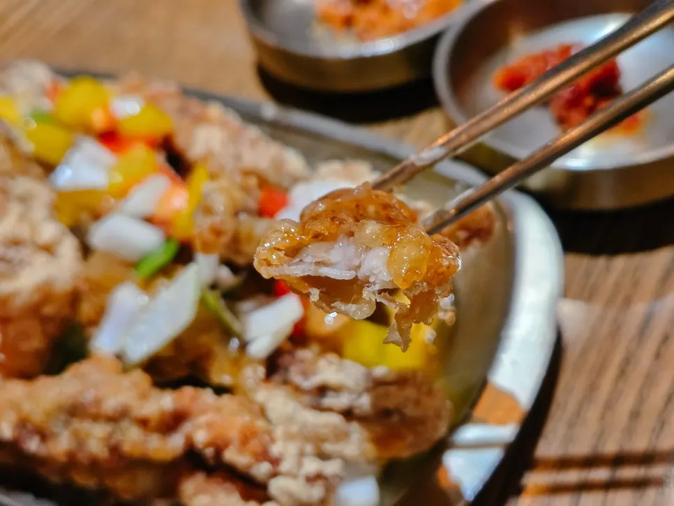 A piece of tangsuyuk picked up with chopsticks