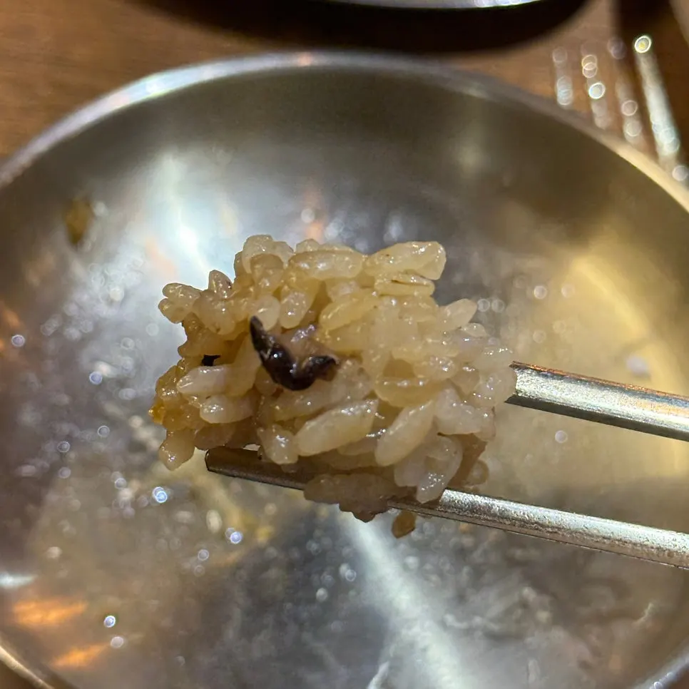 A piece of oak-fired chicken dipped in white sauce