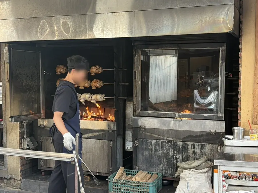 Oak wood-fired grill turning outside the restaurant
