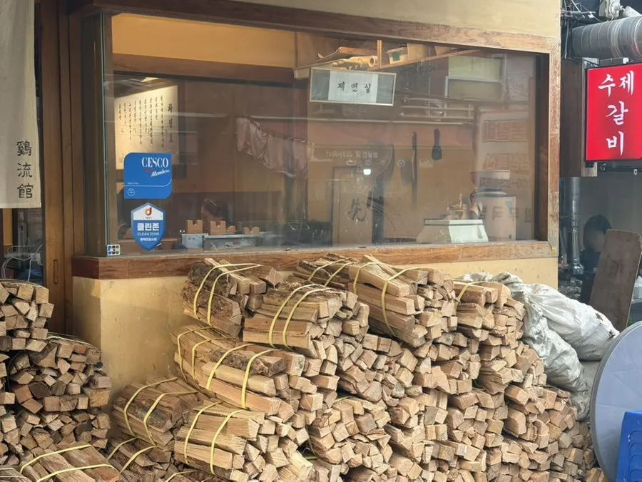 Stacked oak firewood outside Gyeryugwan