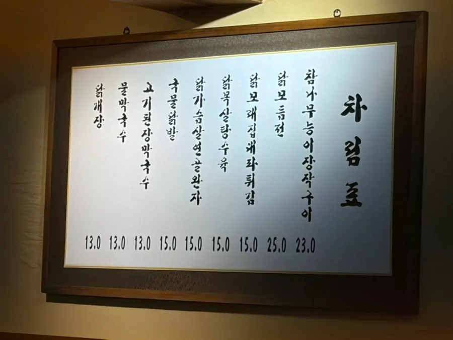 Menu board listing chicken dishes and house-made makguksu