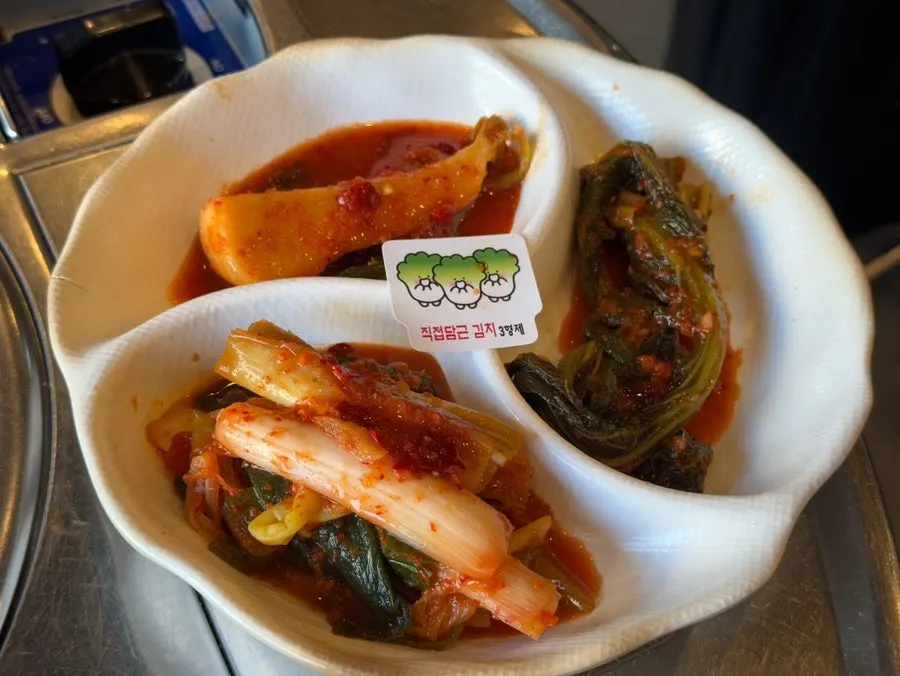 House-made scallion kimchi, mustard leaf kimchi, and altari radish kimchi side dishes