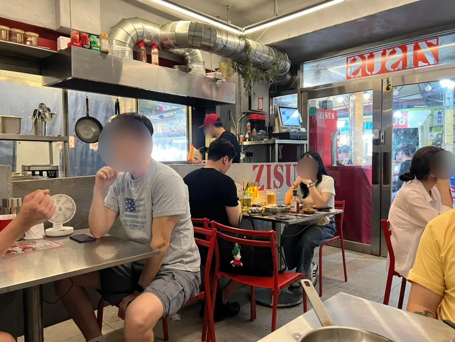 Inside Jjeojeoseu with stainless steel tables and red chairs