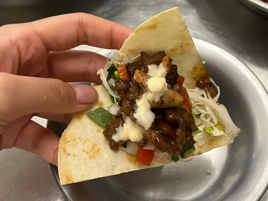 Tortilla wrap topped with meat, vegetables and salsa