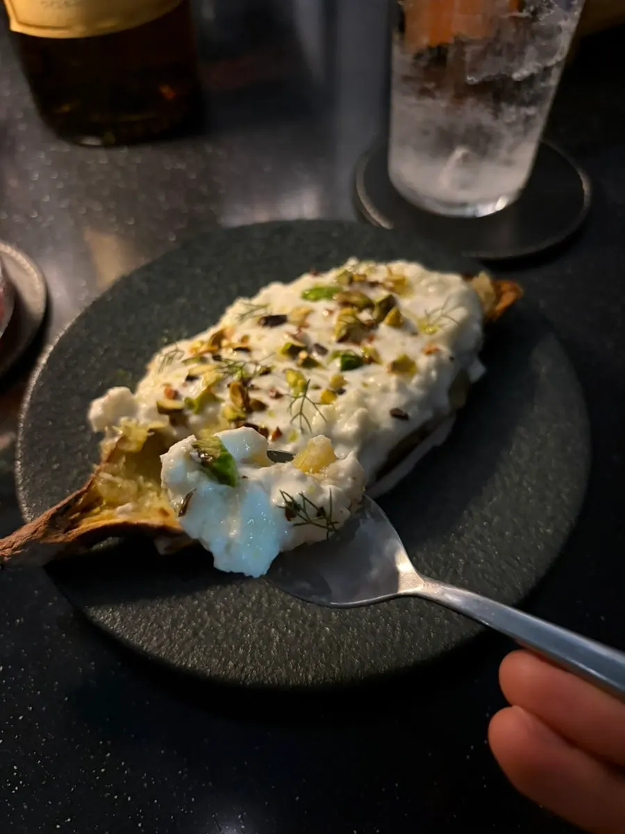 Close-up of roasted sweet potato topped with pistachio sauce