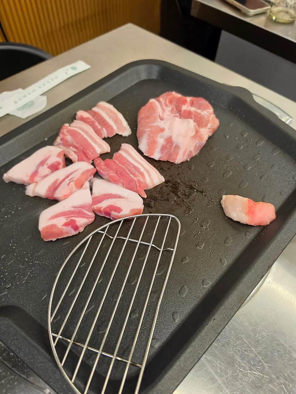 불판 옆에 함께 세팅된 김치와 고기 접시