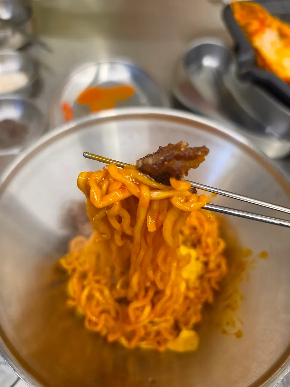 구운 고기 한 점을 얹은 불닭볶음면 한 젓가락