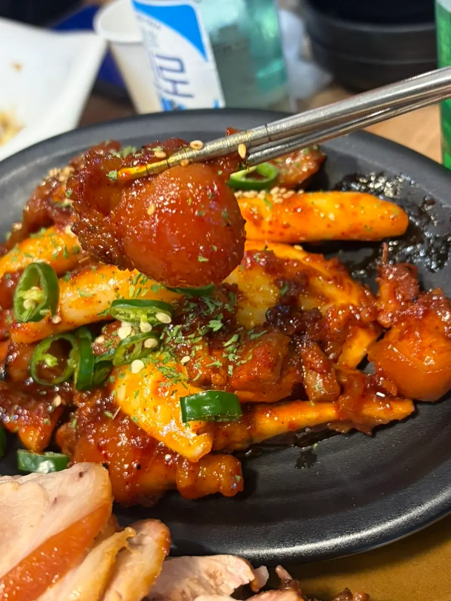 Smoky spicy jokbal served with rice cake pieces