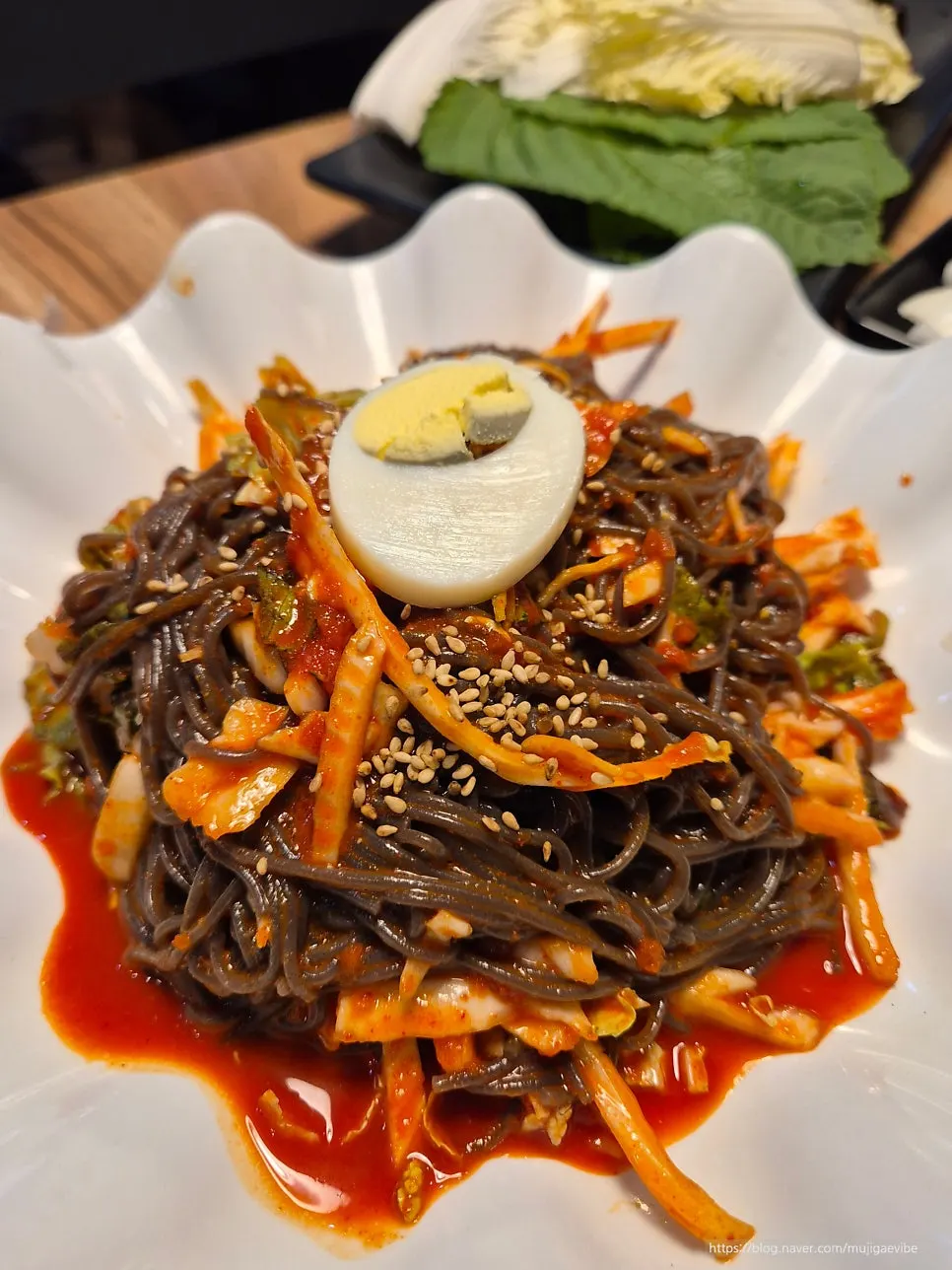 Mixing jaengban makguksu full of vegetables