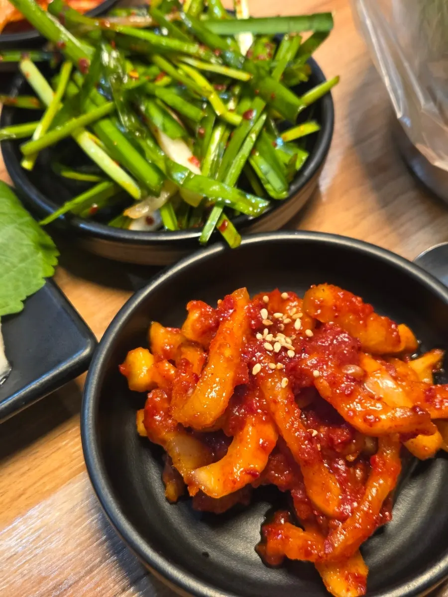 Bossam kimchi, radish kimchi, chive salad, and other side dishes