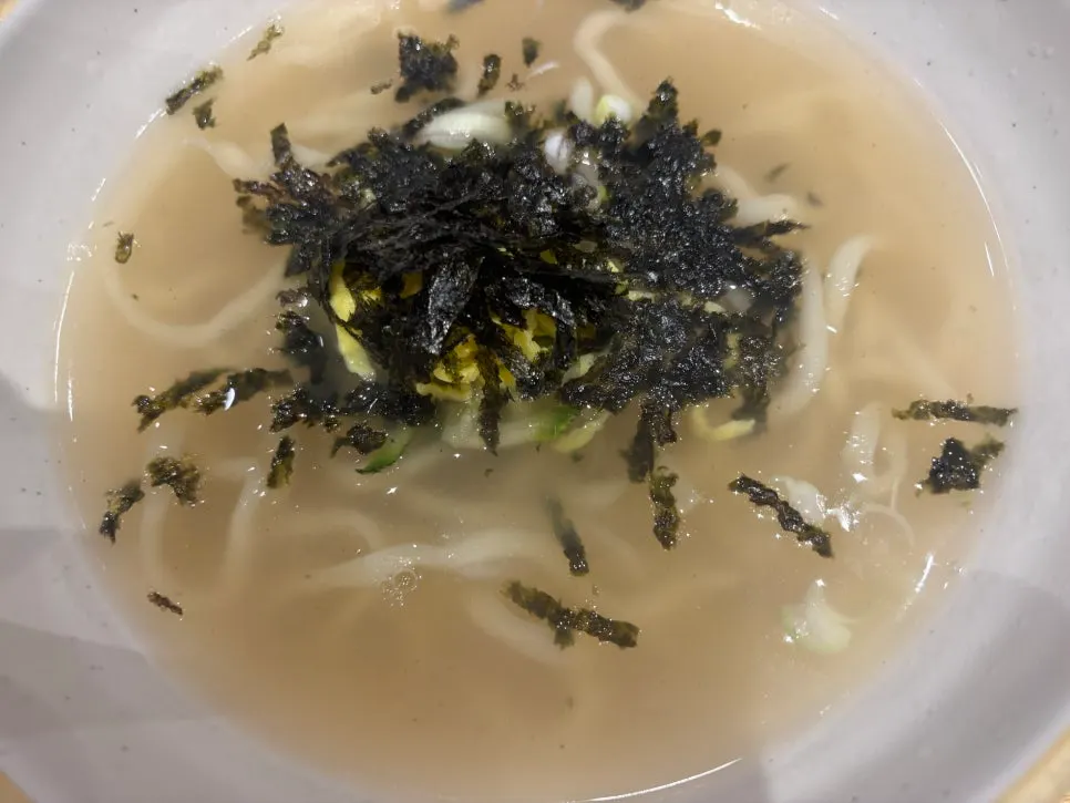 Handmade kalguksu topped with seaweed flakes and cucumber egg garnish