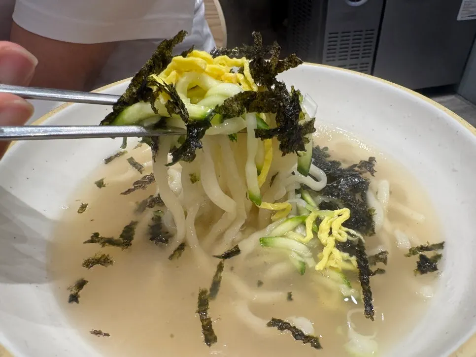 Handmade kalguksu noodles lifted with chopsticks