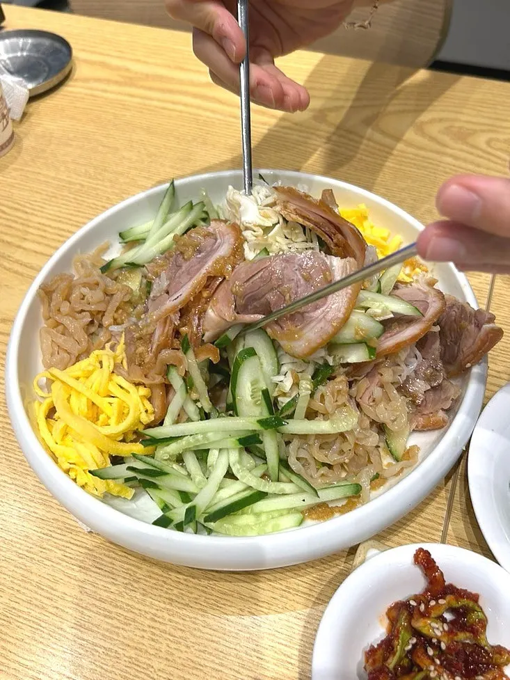 Busan naengchae jokbal piled with cucumber slices and egg garnish