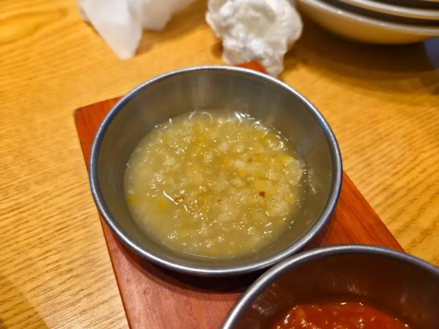 Front-leg jokbal being dipped in garlic sauce
