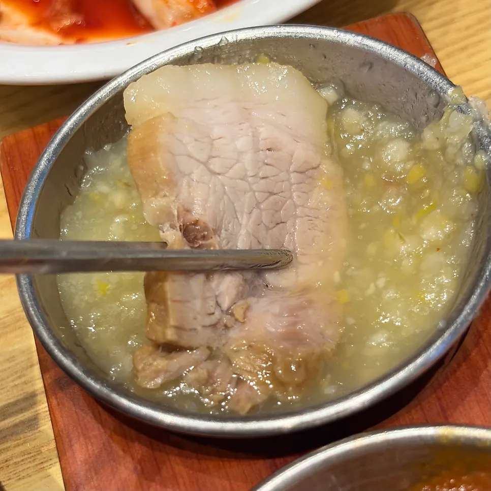 A piece of bossam served with garlic sauce