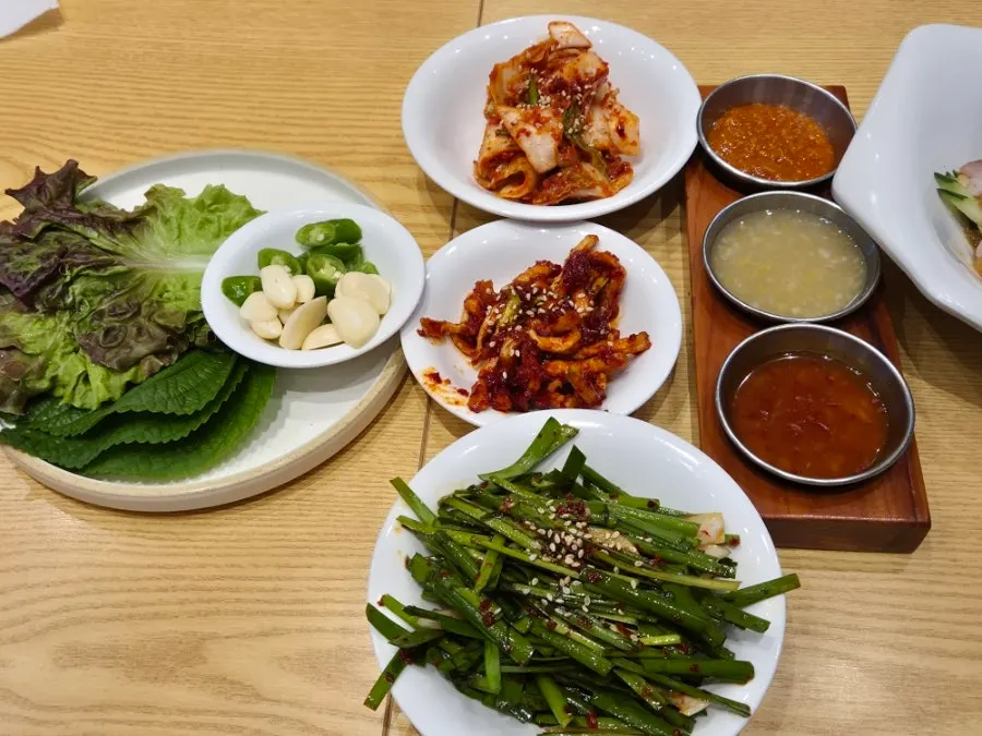 쌈 채소와 반찬, 소스가 깔린 테이블