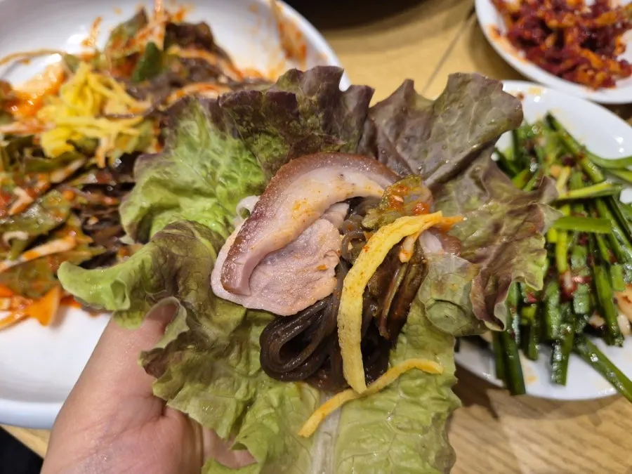 막국수 면 위에 올린 족발 한 점