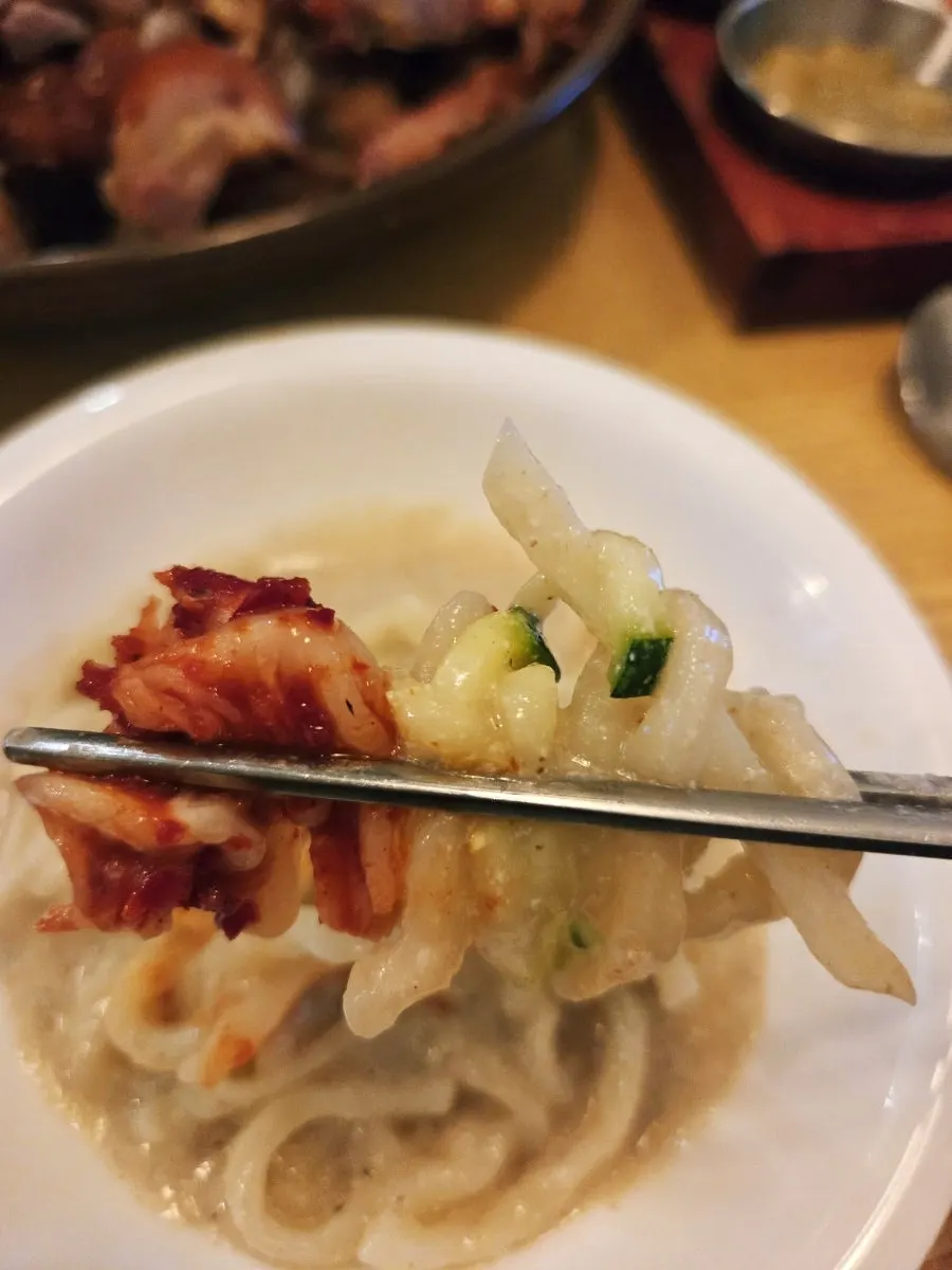 Perilla kalguksu topped with homemade persimmon geotjeori