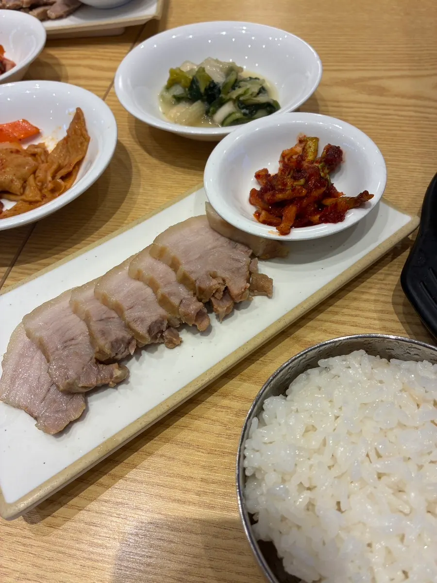 순두부찌개 보쌈정식과 보리밥이 함께 놓인 상