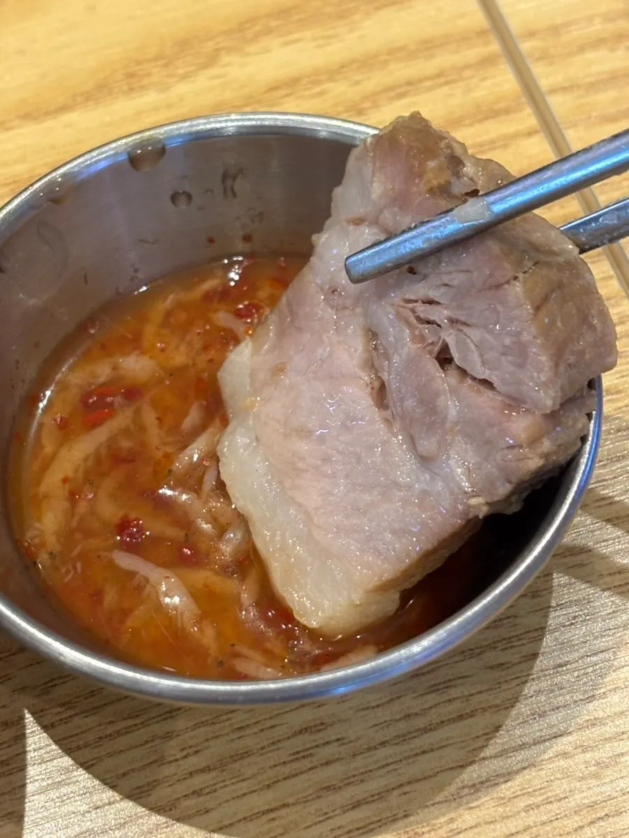 A piece of bossam dipped in salted shrimp