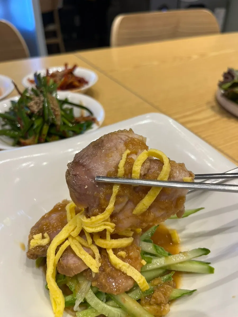 A lettuce wrap with jokbal, garlic, and chives