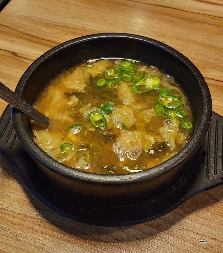 Cabbage soybean paste soup served simmering in a stone pot