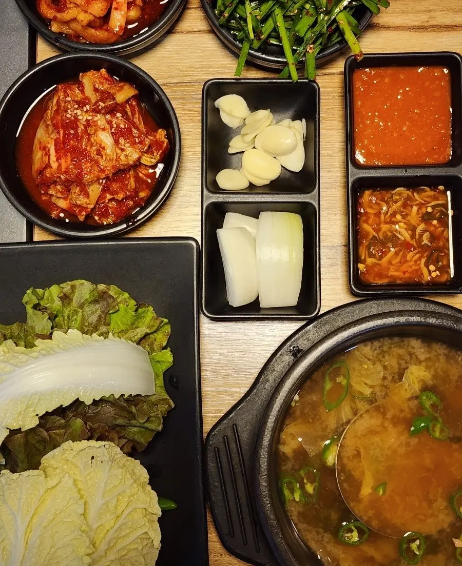 Side dish spread including radish kimchi and fresh kimchi