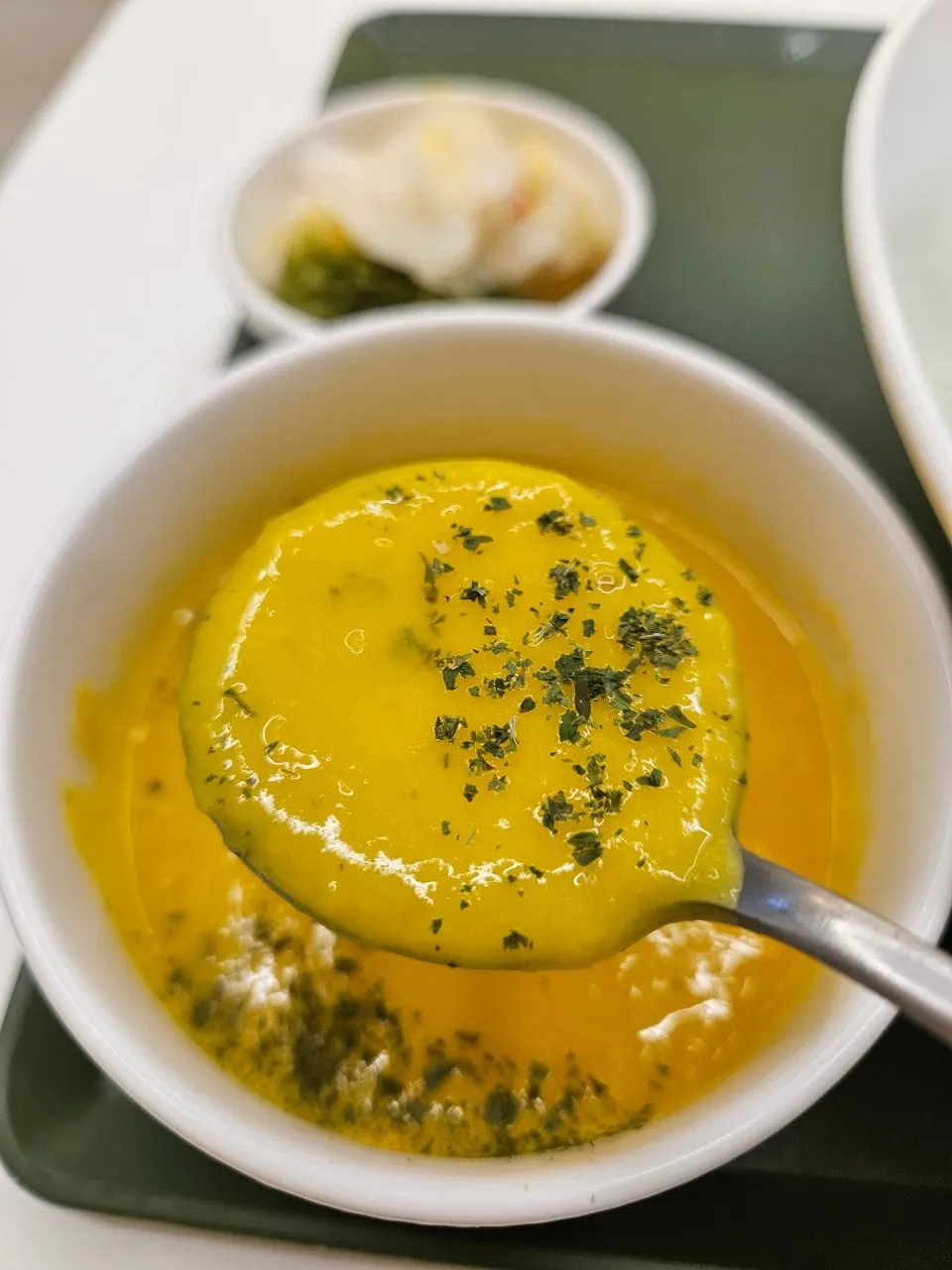 A spoonful of pumpkin cream soup lifted up