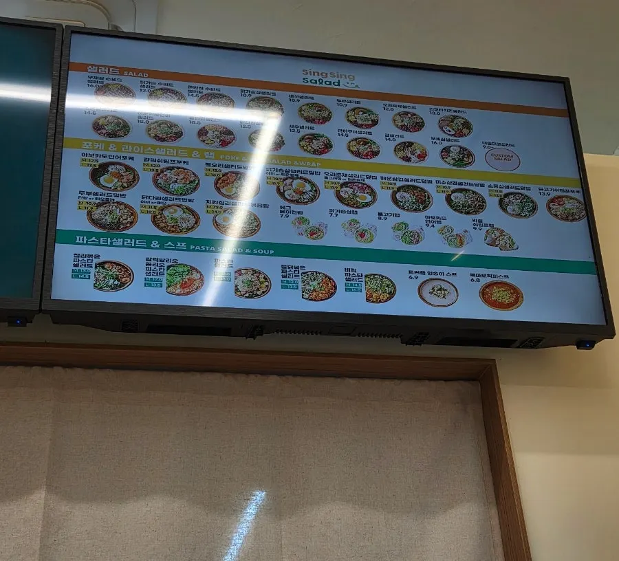Menu board showing salads, poke, pasta, soup and wraps