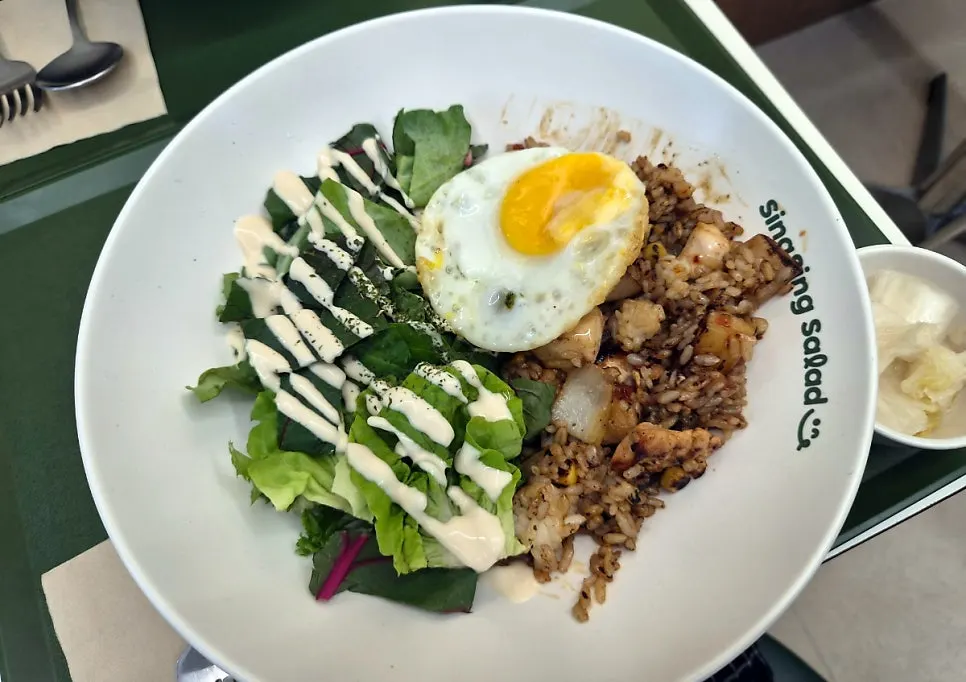 Two salad bowls served with white kimchi presented like pickles