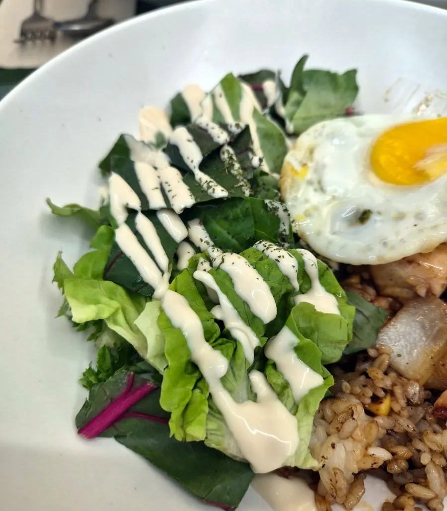 Chili stir-fry salad rice bowl topped with a fried egg