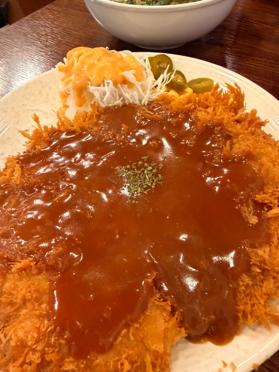 돈까스 한 조각을 집어 든 모습