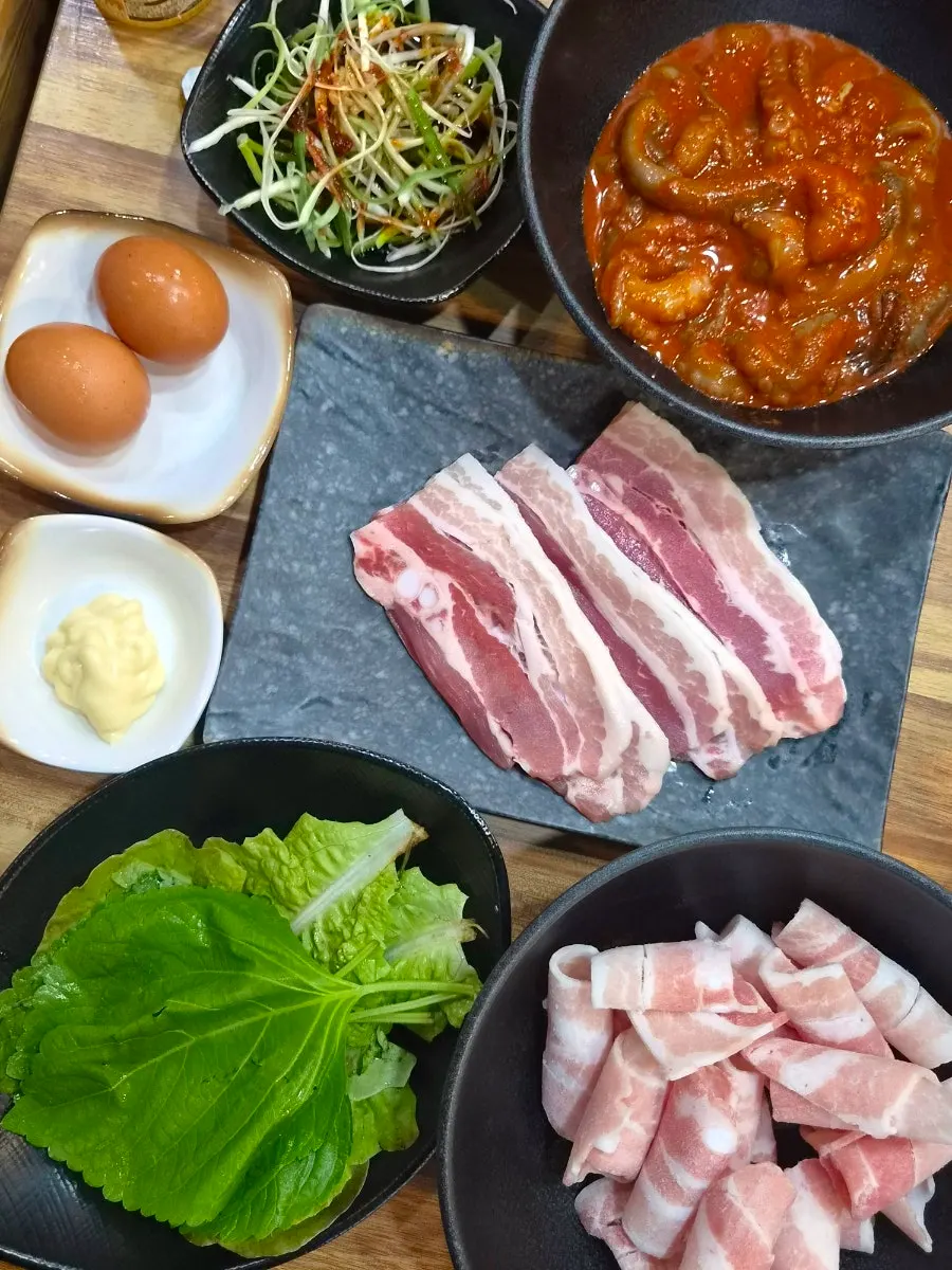 A spread of jjukkumi and meat brought from the self-serve bar
