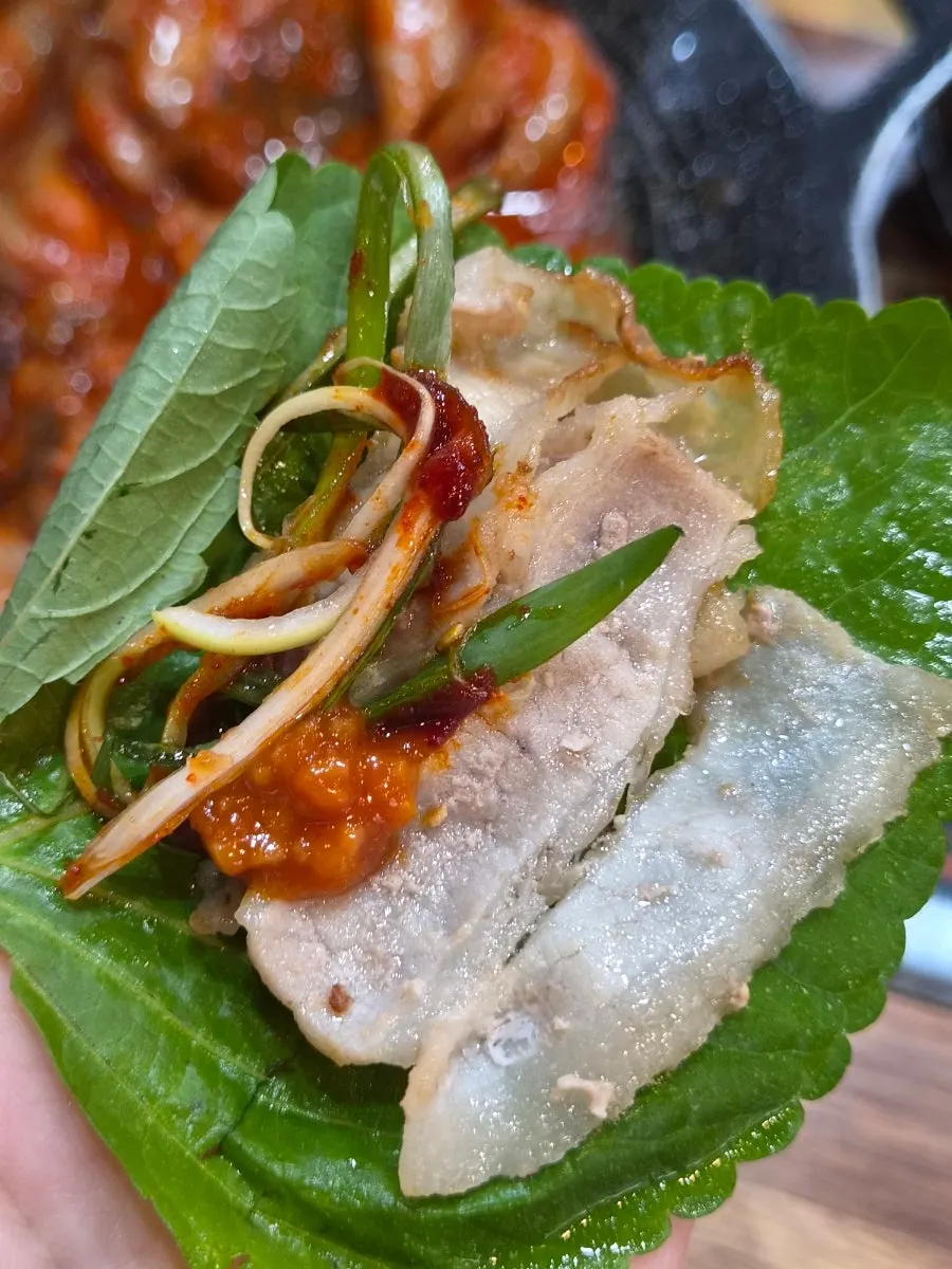 Thin-sliced pork belly wrap topped with scallion salad