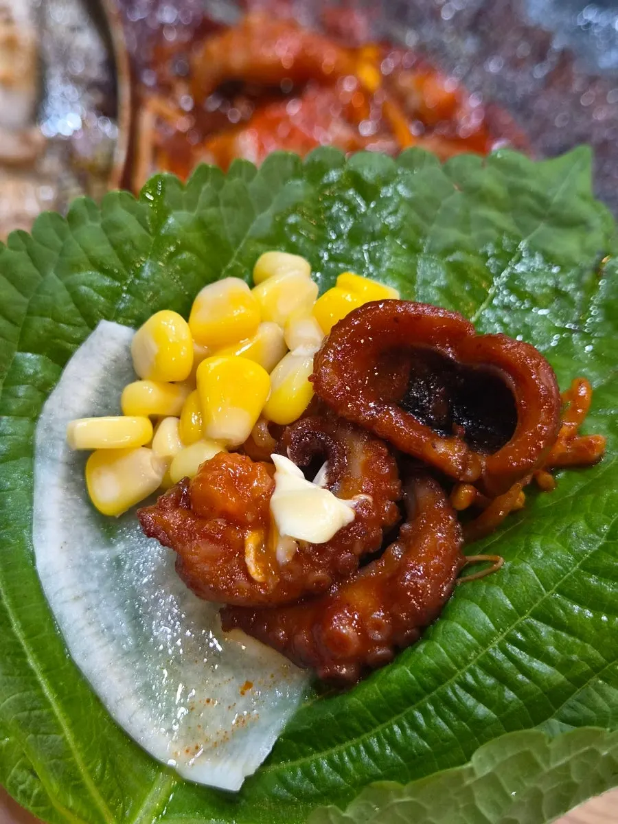 A single bite-sized wrap with both jjukkumi and meat