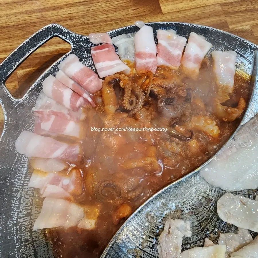Grilling fresh pork belly on one side of the grill