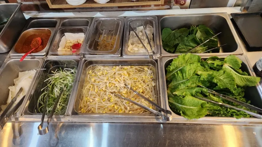 상추 깻잎 콩나물 마늘 파채가 놓인 셀프바