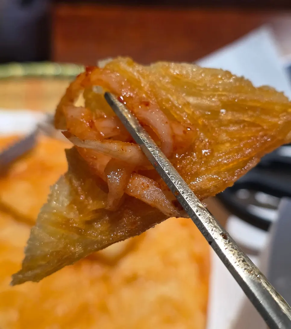 Picking up a piece of potato pancake with chopsticks