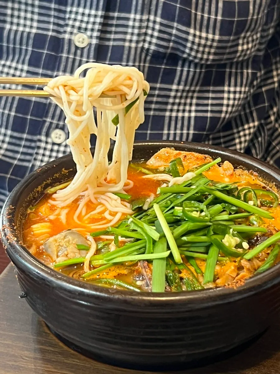 A bowl of sundaeguk with self-serve bar somyeon noodles added