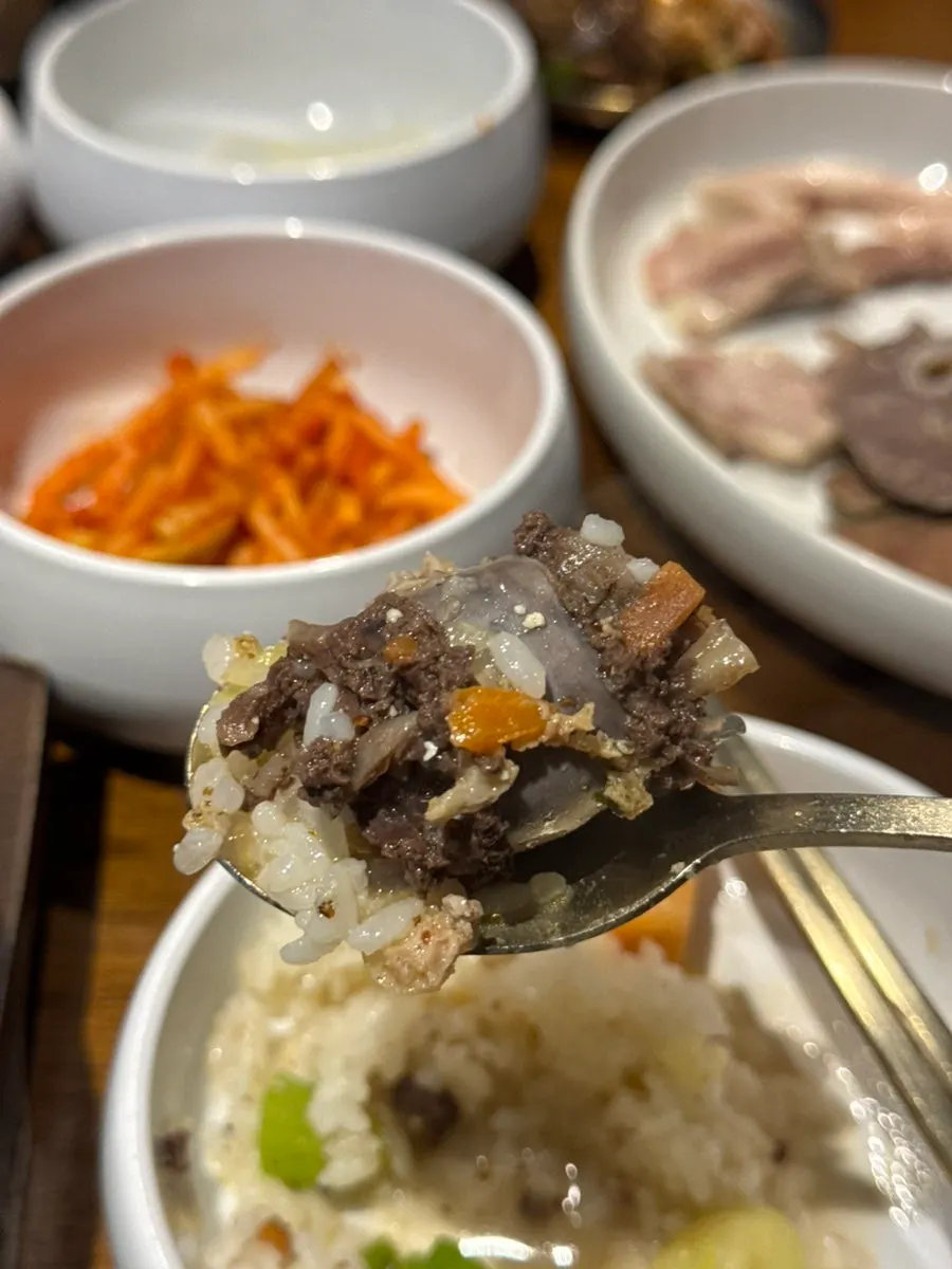A spoonful of rice mixed with sundaeguk topped with soondae