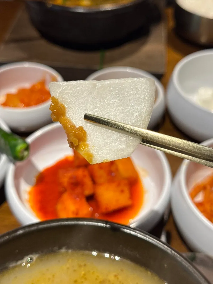 Onion dipped in ssamjang alongside the sundaeguk spread