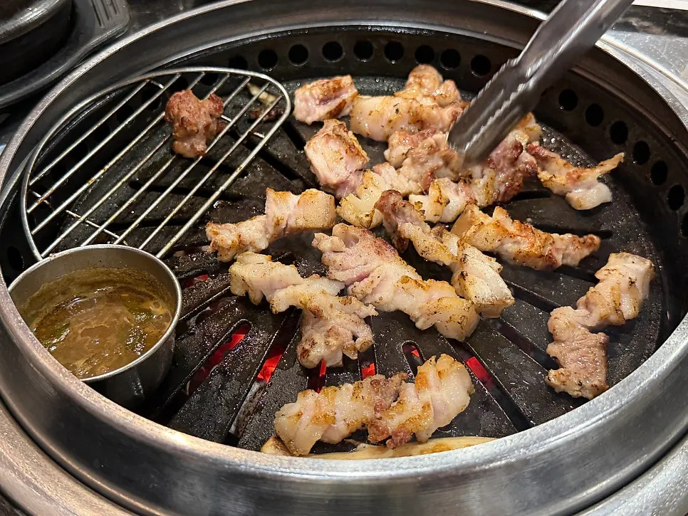 Pork belly grilling over charcoal