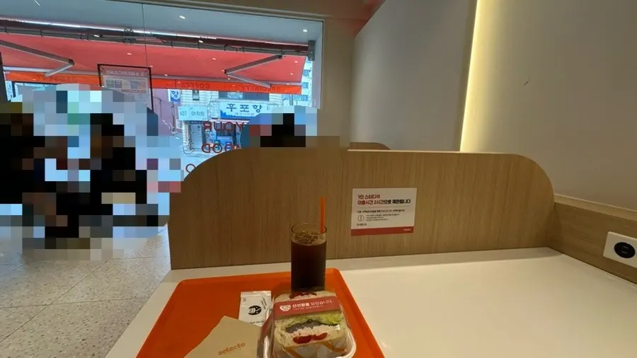 1人讀書座位上放著的冰美式和雞胸三明治